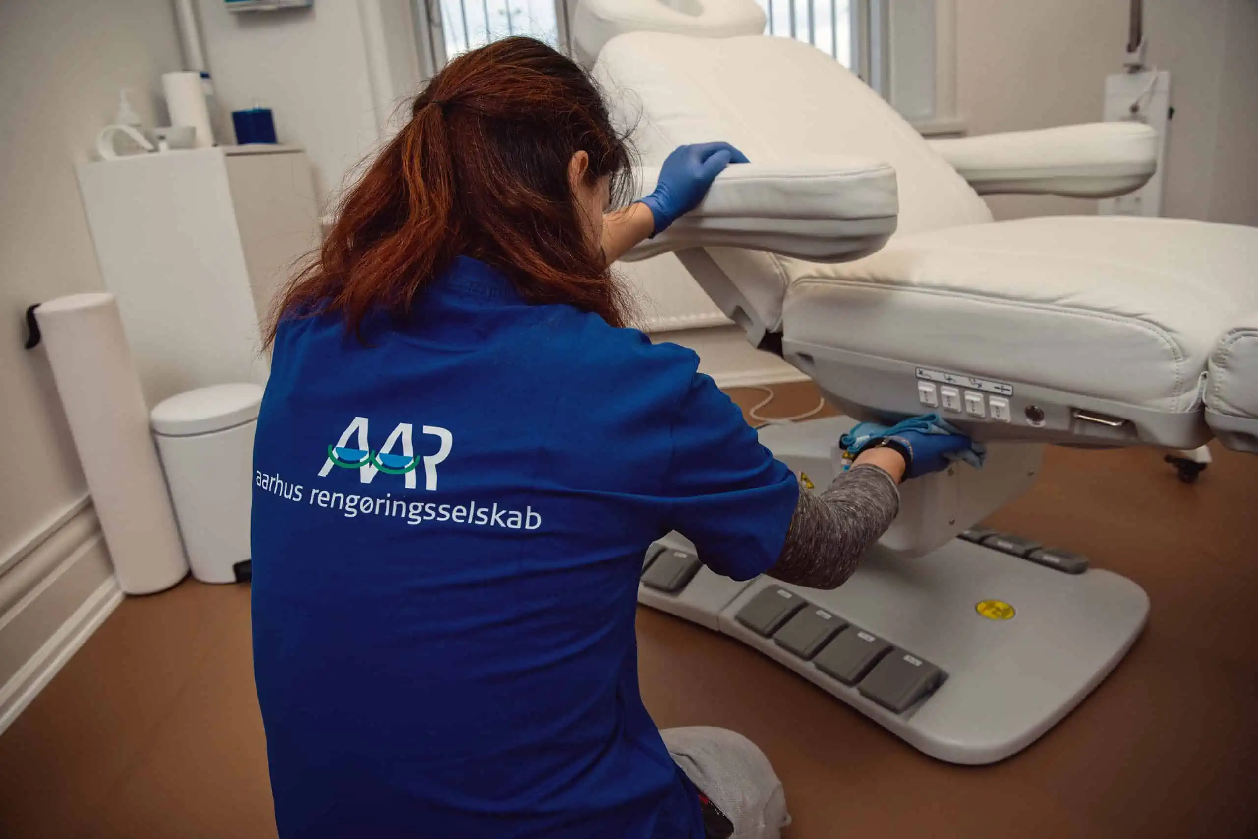 Rengøringsassistent rengør klinikstol på en klinik i Aarhus